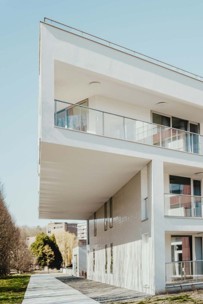 Contemporary white building with an extended balcony and sharp angles.