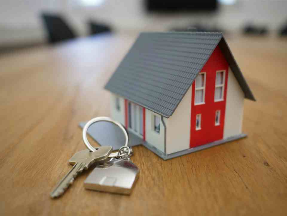 Model house and keys symbolizing real estate ownership.